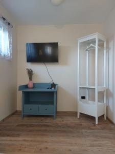 Habitación con mesa azul y TV en la pared. en APARTMENT KORTINE, en Sečovlje