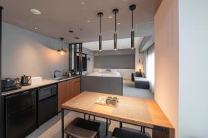 a kitchen with a table and a kitchen with a sink at Hotel Keihan Namba Grande in Osaka