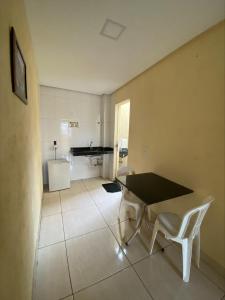 a room with a table and chairs and a piano at Pousada Elita in Divinópolis