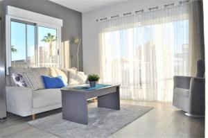 un soggiorno con divano e tavolo di Three bedroom top apartment by the beach a Santa Pola