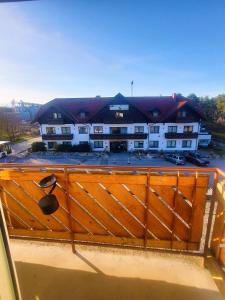 un bâtiment avec une porte en bois en face d'un parking dans l'établissement Pension Schwartzwirt, à Neusiedl am Steinfelde