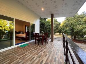 a porch of a house with a table and chairs at Naisang Hostel in Chumphon
