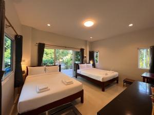 a hotel room with two beds and a balcony at Naisang Hostel in Chumphon