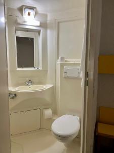 a small bathroom with a toilet and a sink at Hostal - Restaurante Asador Esperanza in Huesca