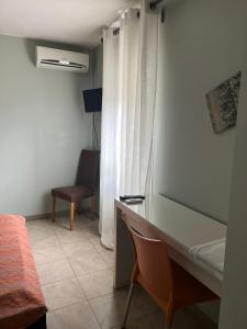 1 dormitorio con escritorio y silla junto a una ventana en Hostal - Restaurante Asador Esperanza en Huesca