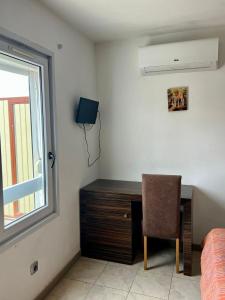 1 dormitorio con escritorio, silla y ventana en Hostal - Restaurante Asador Esperanza en Huesca