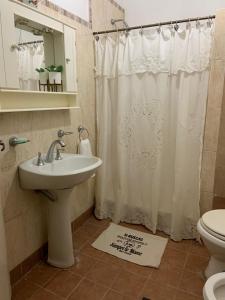 a bathroom with a sink and a shower curtain at La Mitre in Santiago del Estero