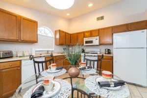 a kitchen with two tables and a refrigerator at 16150EGRET- Sun Chaser (S) in Orlando