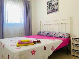 1 dormitorio con 1 cama con manta rosa y blanca en Duplex con una vista impresionantes a Calpe, en La Canuta