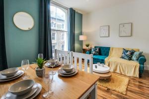 a dining room with a table and a living room at Sleek & Stylish Apartment in the Heart of the City in Nottingham