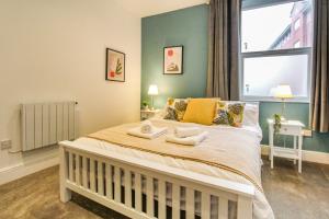 1 dormitorio con 1 cama con 2 toallas en Sleek & Stylish Apartment in the Heart of the City en Nottingham