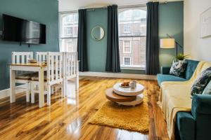 a living room with a couch and a table at Sleek & Stylish Apartment in the Heart of the City in Nottingham