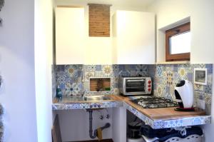 - une petite cuisine revêtue de carrelage bleu et blanc dans l'établissement DOG HOUSE FROM POMPEI-AMALFI, à SantʼAntonio Abate