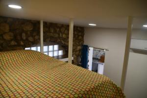 - une chambre avec un lit et un mur en rondins dans l'établissement DOG HOUSE FROM POMPEI-AMALFI, à SantʼAntonio Abate