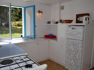 uma cozinha com armários brancos, um fogão e uma janela em Maison Le Palais, 5 pièces, 8 personnes - FR-1-418-159 em Le Palais