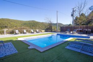 a large swimming pool with chairs at Vila Caelus masía boutique in Rubio