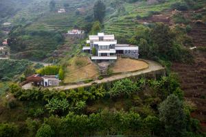 a house on top of a hill with trees at amã Stays & Trails Kailash House in Kodaikānāl +7 photos