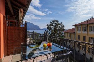 a balcony with a table and chairs and a view of the water at Residenza Ticino in Verbania