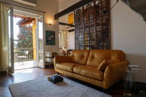 a living room with a brown couch and a table at Residenza Ticino in Verbania