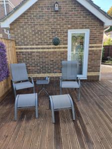two chairs and a table on a deck at Modern immaculate studio with aircon & parking in Bristol