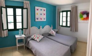 two beds in a bedroom with blue walls and windows at La Venecia de Canarias in Puerto de Mogán +98 photos