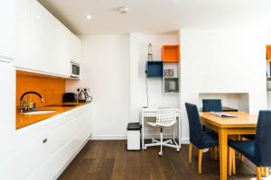 a kitchen and dining room with a table and chairs at Charming 2 Bedroom Apartment in Kentish Town in London