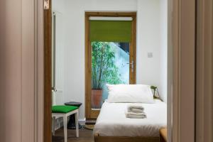 a bedroom with a bed and a green window at Charming 2 Bedroom Apartment in Kentish Town in London