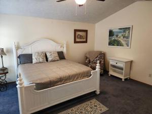 ein Schlafzimmer mit einem großen weißen Bett und einem Stuhl in der Unterkunft A Wine Country Home in Yamhill County 