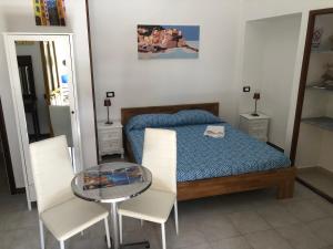 una piccola camera con letto e tavolo in vetro di Affittacamere l'Acciuga a La Spezia