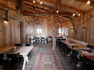 a restaurant with wooden walls and tables and chairs at stettli resort in Parpan
