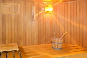 una pequeña sauna con cubo y utensilios de madera en Villa Nora, en Faulensee
