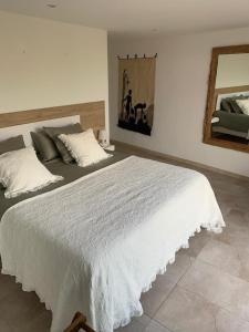 una camera da letto con un grande letto bianco e uno specchio di Casa Las Palmeras a Granadilla de Abona