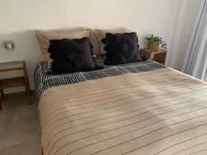 una camera da letto con un grande letto con cuscini neri di Casa Las Palmeras a Granadilla de Abona