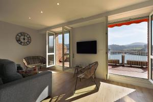 een woonkamer met een bank en een groot raam bij Xatetto Etxea Ocean View in Zumaia