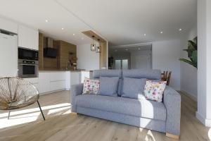 sala de estar con sofá azul y cocina en Xatetto Etxea Ocean View, en Zumaia