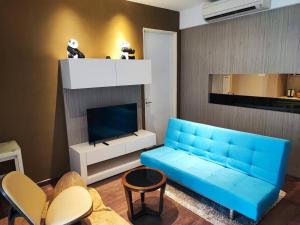 a living room with a blue couch and a tv at 小熊猫亚庇沙巴市区 Little Panda Riverson Imago Kota Kinabalu Sabah Free WIFI in Kota Kinabalu