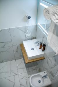 un bagno bianco con lavandino e WC di Michelangelo Vatican Rooms a Roma Altre 100 foto