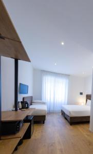 una camera d'albergo con due letti e una scrivania di Michelangelo Vatican Rooms a Roma