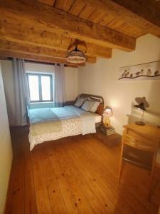 a bedroom with a bed and a wooden floor at Aux balcons de la vallée in Soultzeren