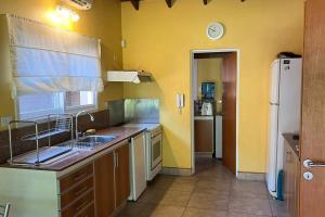 cocina con fregadero y nevera en Casa en Ing. Maschwitz con gran parque y pileta en Ingeniero Maschwitz