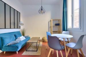 een woonkamer met een blauwe bank en een tafel bij Cosy apartment with terrace near the center in Marseille