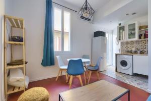een woonkamer met een tafel en stoelen en een keuken bij Cosy apartment with terrace near the center in Marseille