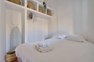 een witte slaapkamer met een wit bed en handdoeken erop bij Cosy apartment with terrace near the center in Marseille