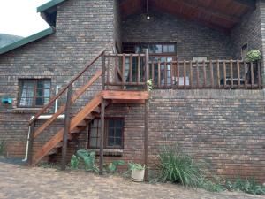a wooden staircase on the side of a brick building at Sharon's Dream - Self Catering Apartment in Hartbeespoort