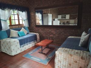 a living room with a couch and a table and a mirror at Sharon's Dream - Self Catering Apartment in Hartbeespoort