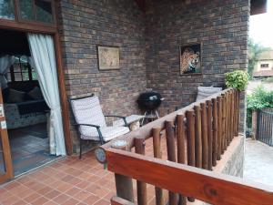 a porch with a wooden fence and a brick wall at Sharon's Dream - Self Catering Apartment in Hartbeespoort