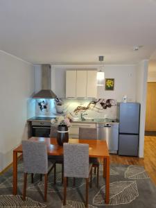 Una cocina con mesa y sillas y un refrigerador. en Spacious studio apartment in city center Tallinn, en Tallin