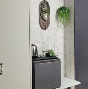 a refrigerator in a kitchen with plants on the wall at Pandora's Guest Lodge in Klerksdorp