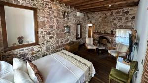 1 dormitorio con cama y pared de piedra en Cunda Konak Nazımaki en Ayvalık
