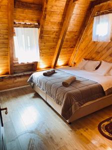 a bedroom with a bed in a wooden cabin at Guesthouse Prrockaj Theth in Theth